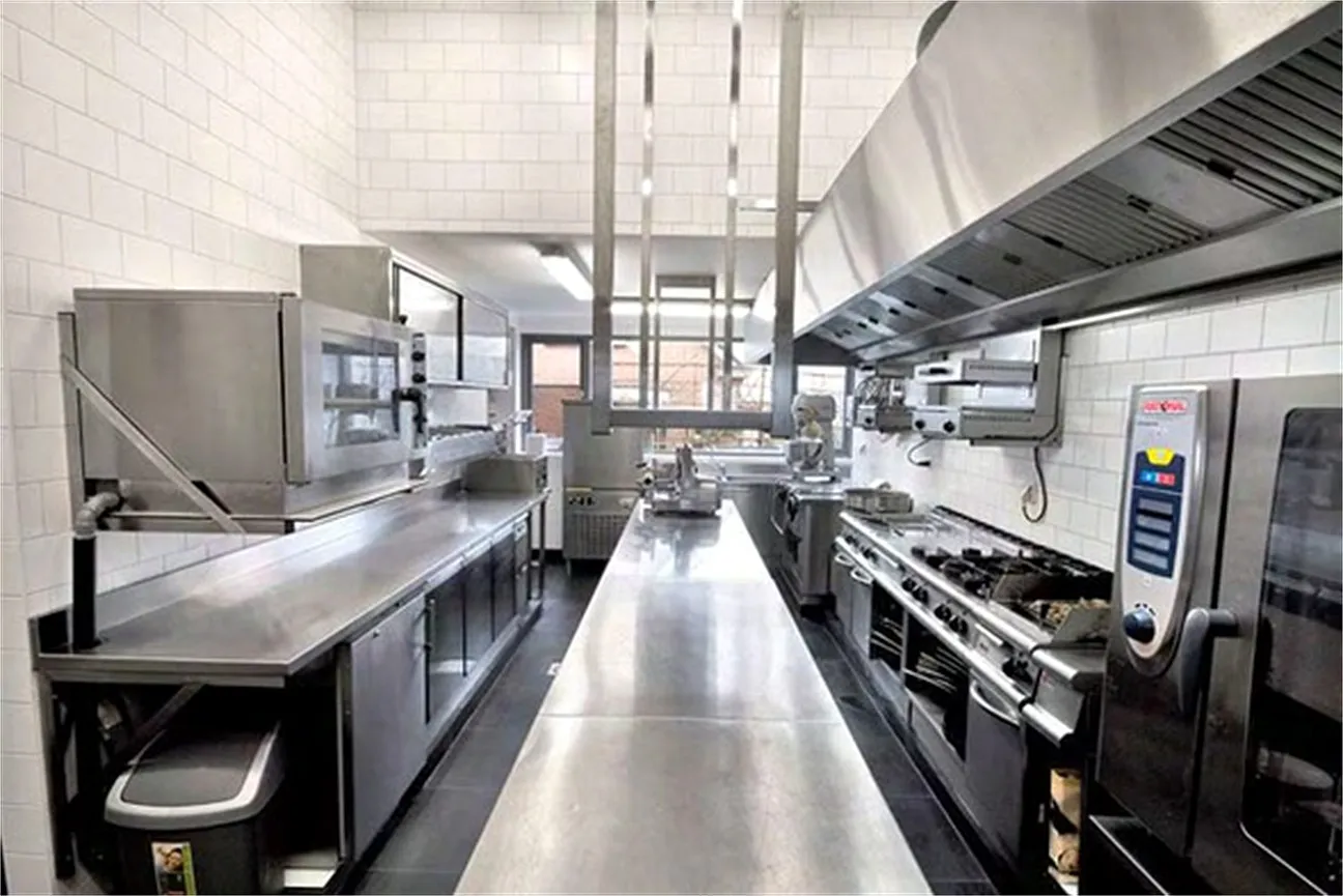 Stainless steel commercial kitchen with cooking line, combi oven and preparation counters